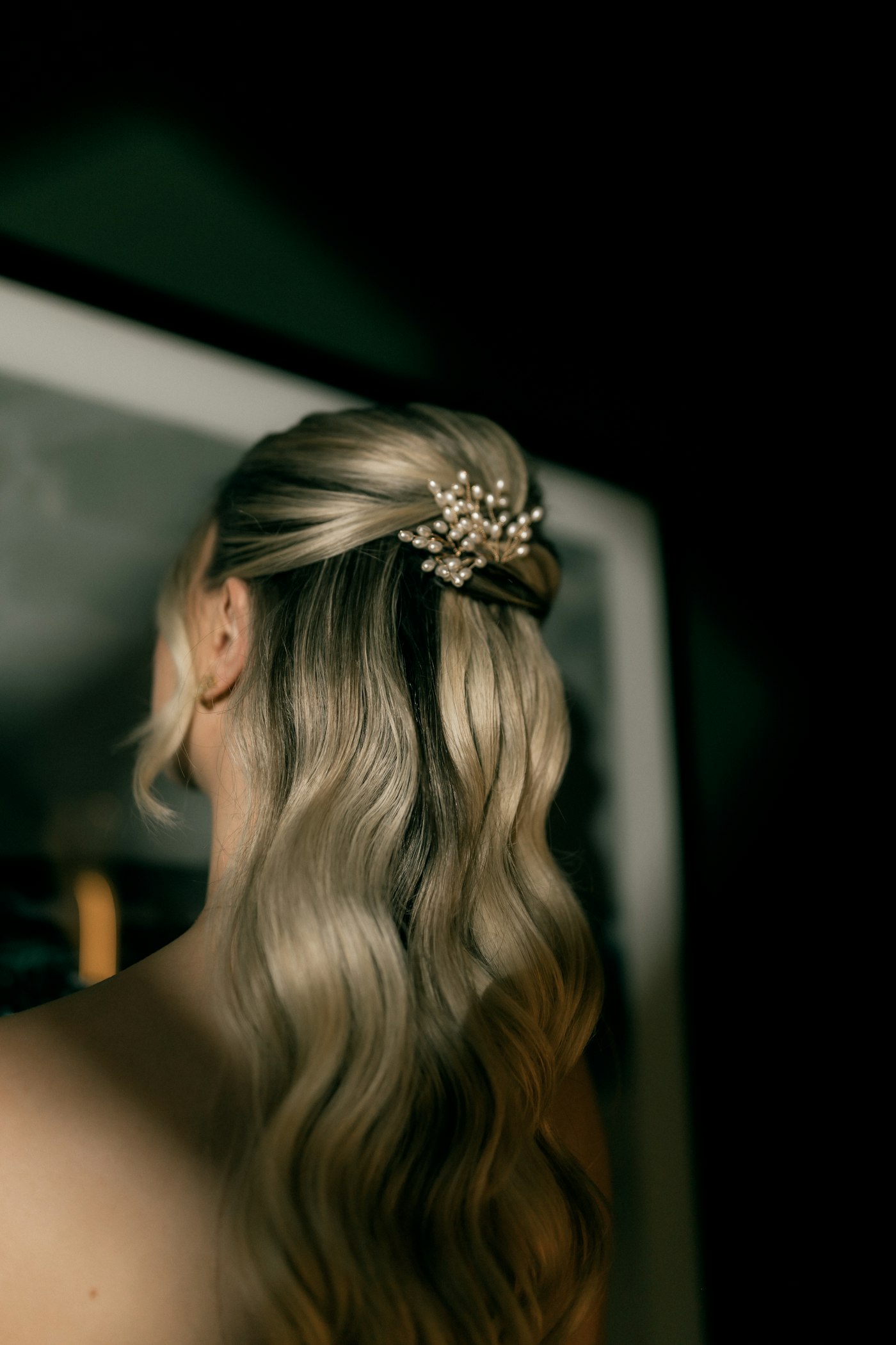 Elegant blonde wavy hair adorned with a pearl accessory
