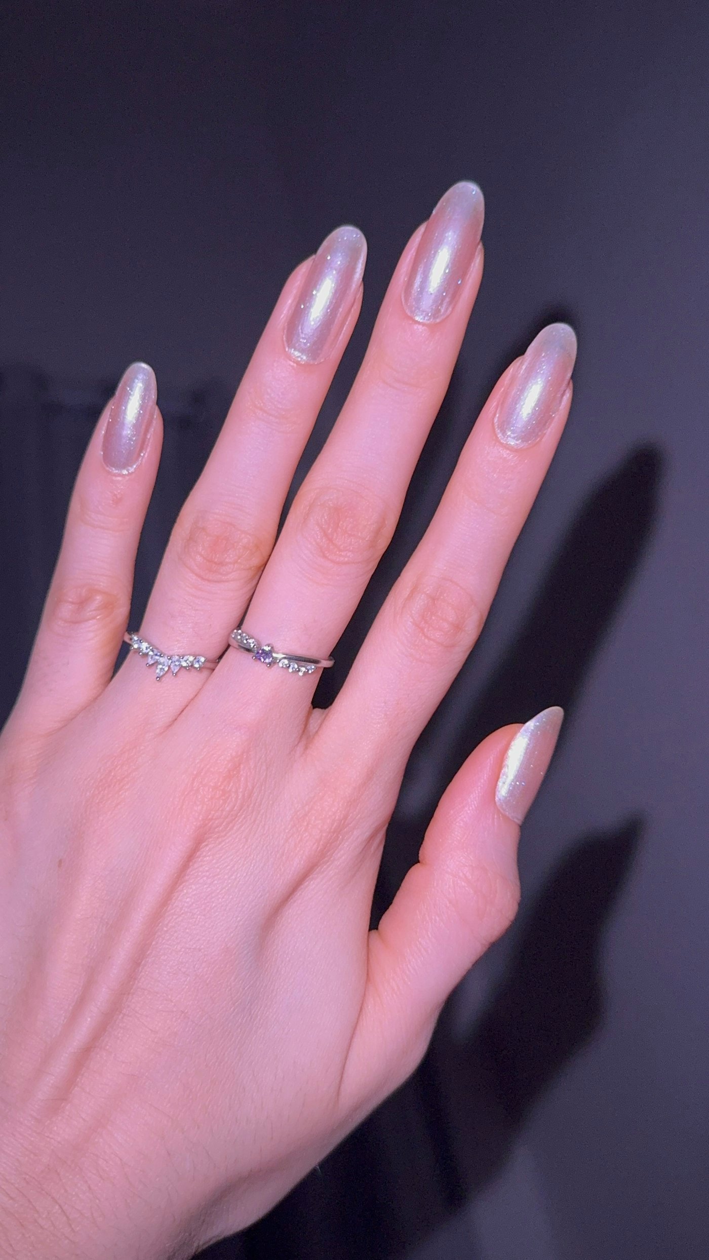 Hand with pearlescent nails and rings