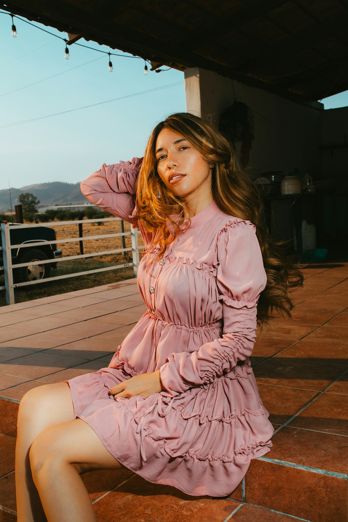 Woman posing outdoors in a pink dress
