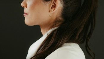 Woman in a white blazer with a dark ponytail and the headline ponytail hairstyles