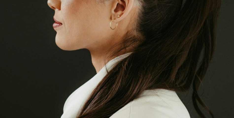 Woman in a white blazer with a dark ponytail and the headline ponytail hairstyles