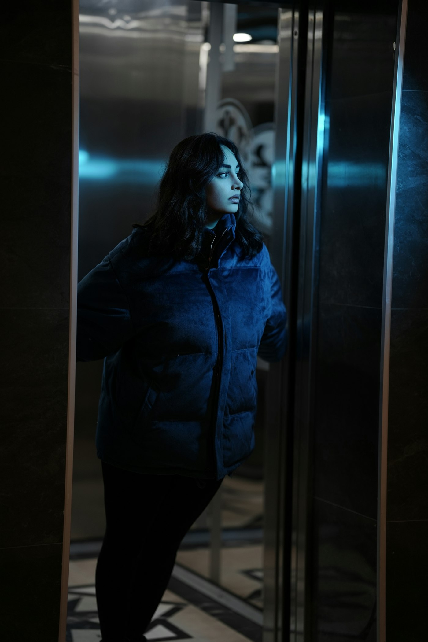 Woman in a puffer jacket standing in an elevator