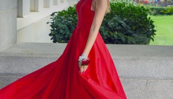 Woman in a red sleeveless dress as red outfit inspiration for a feather trim styling guide