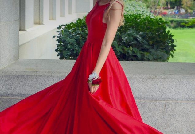 Woman in a red sleeveless dress as red outfit inspiration for a feather trim styling guide