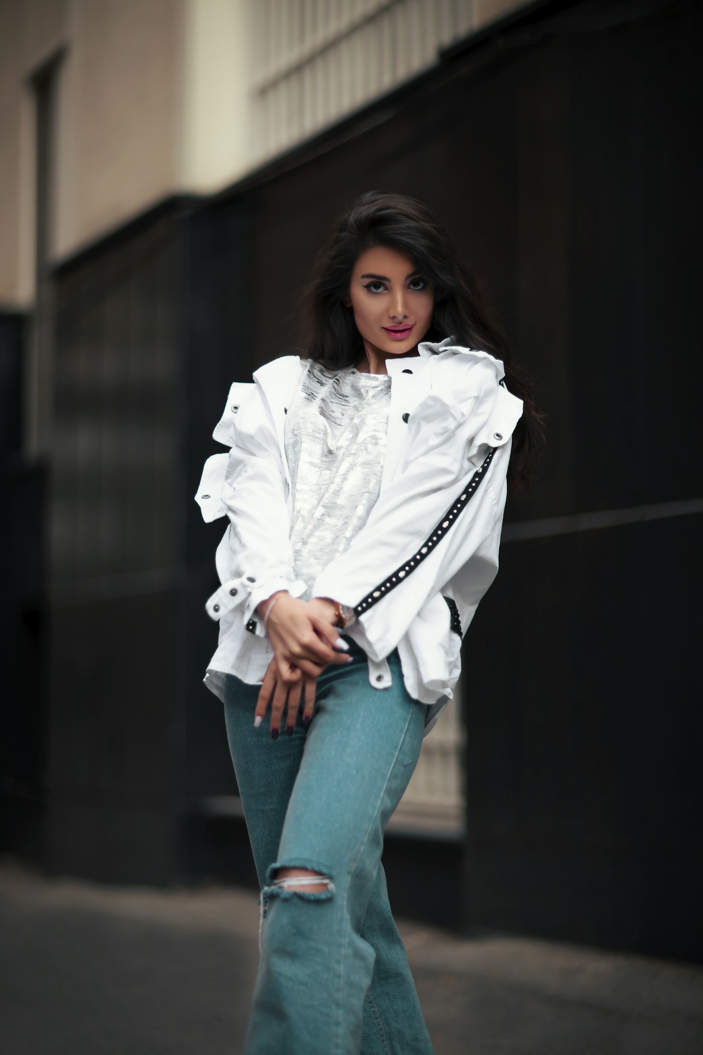 Woman in a white top and ripped jeans, a simple base for a statement jacket