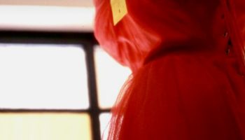 Red dress on a mannequin by a window with the headline red dress with pockets