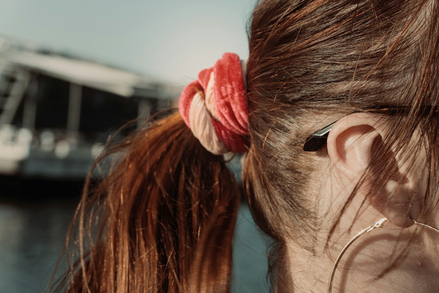 Woman with reddish brown hair tied back with a scrunchie