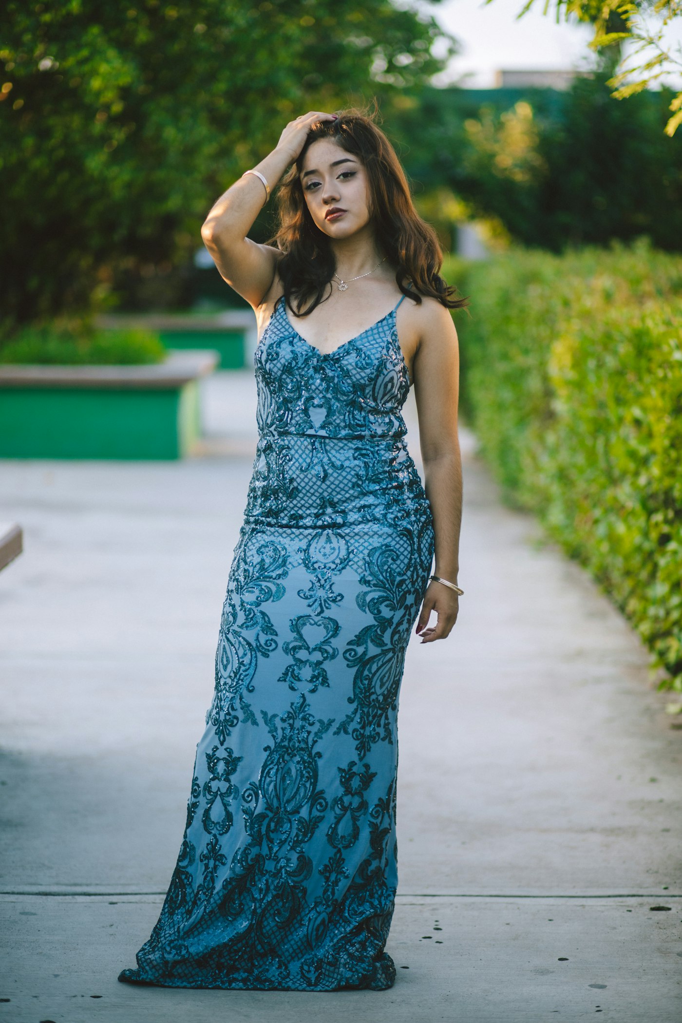 Young woman in a sparkly blue formal dress outdoors