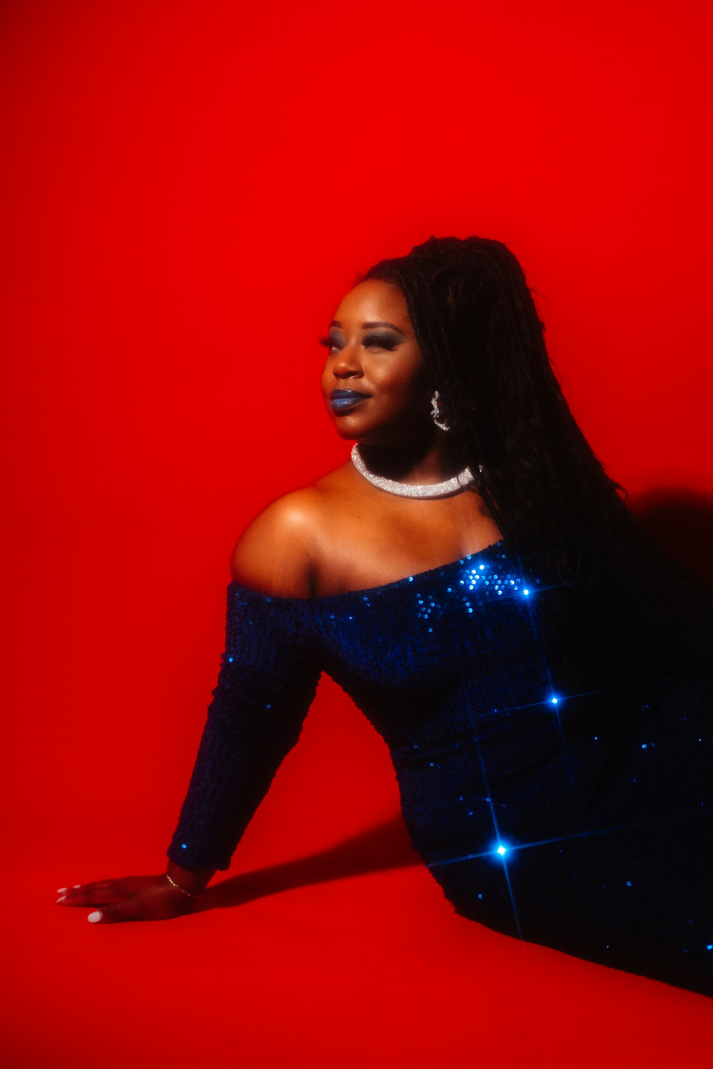 Woman in a sparkly blue dress on a red background