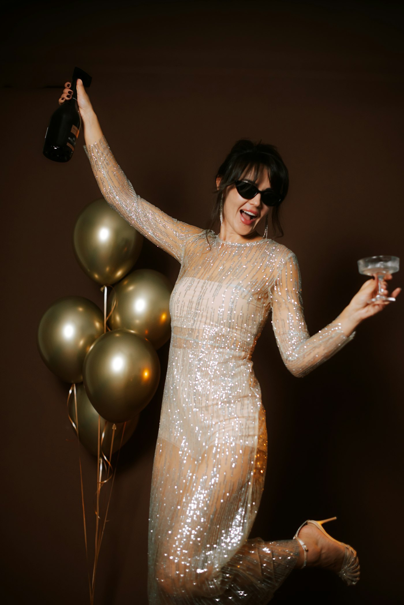 Woman in a sparkly dress celebrating with champagne