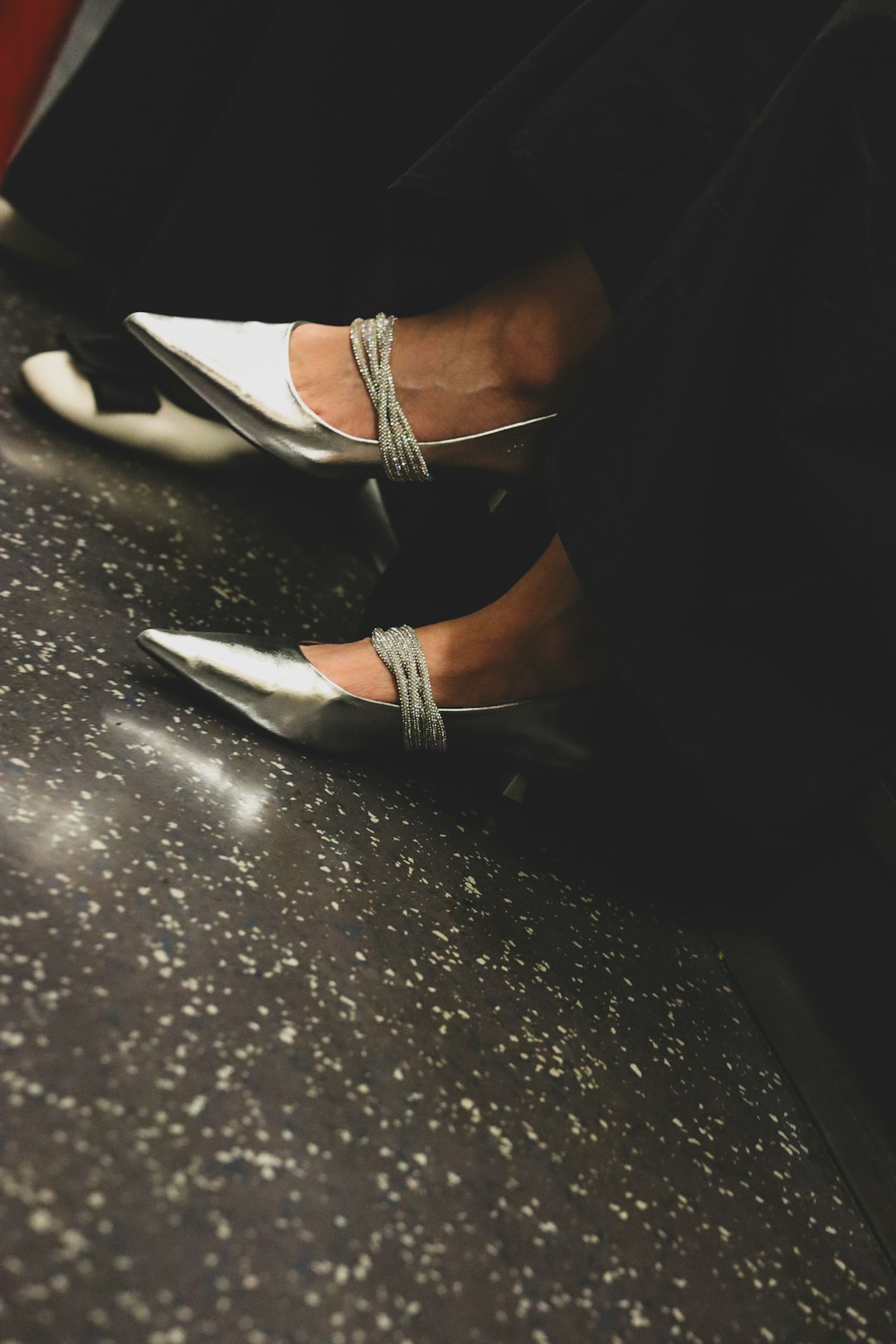 Close up of feet wearing white shoes on a light surface