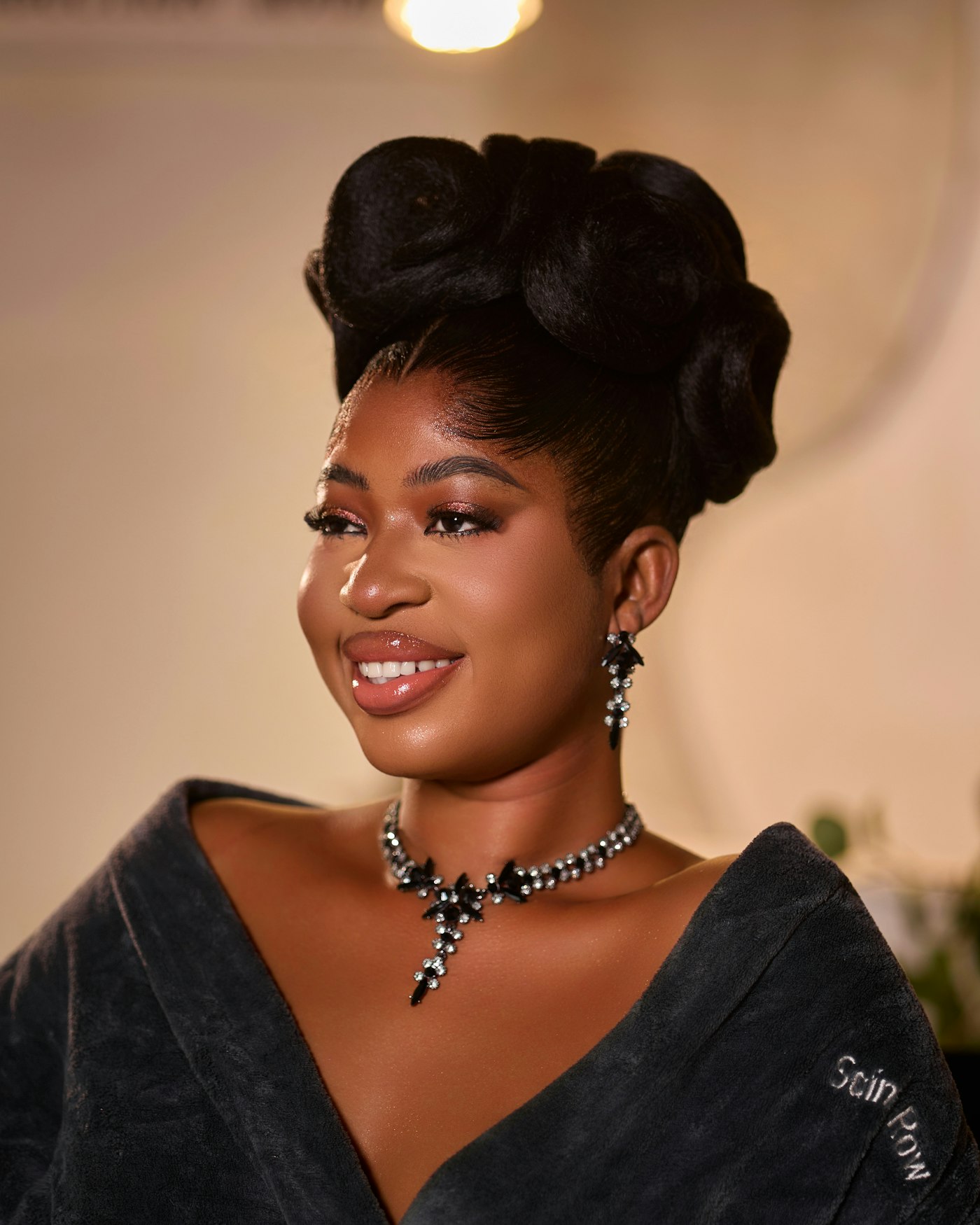 Smiling woman with an elaborate updo and sparkling jewelry