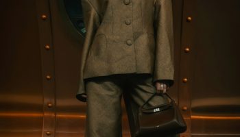 Woman in a brown suit against a copper wall with the headline brown suit done right