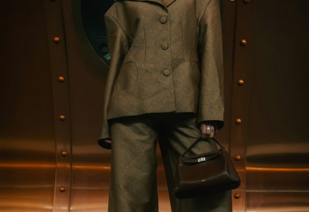 Woman in a brown suit against a copper wall with the headline brown suit done right