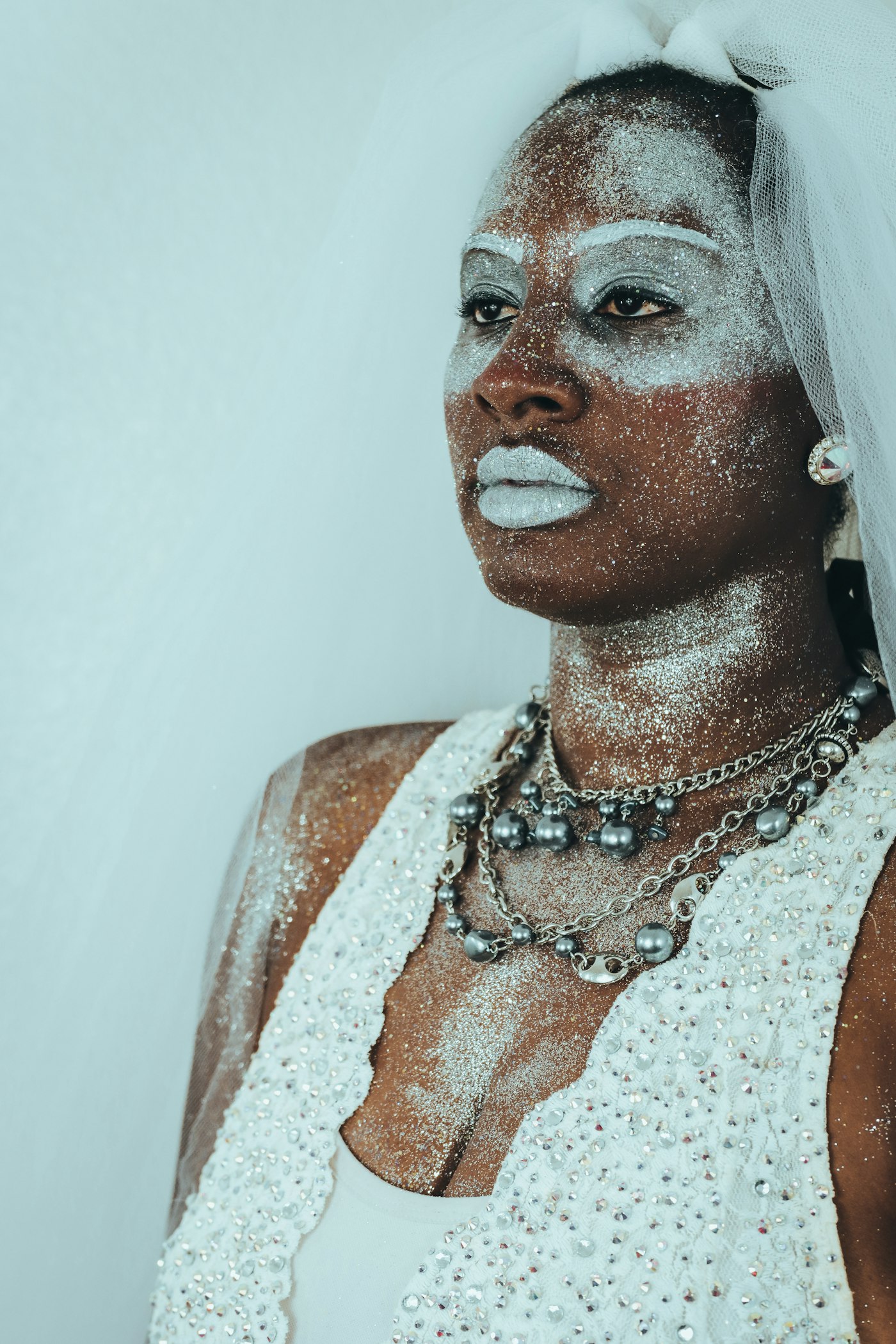 Woman with white glitter makeup and a white dress