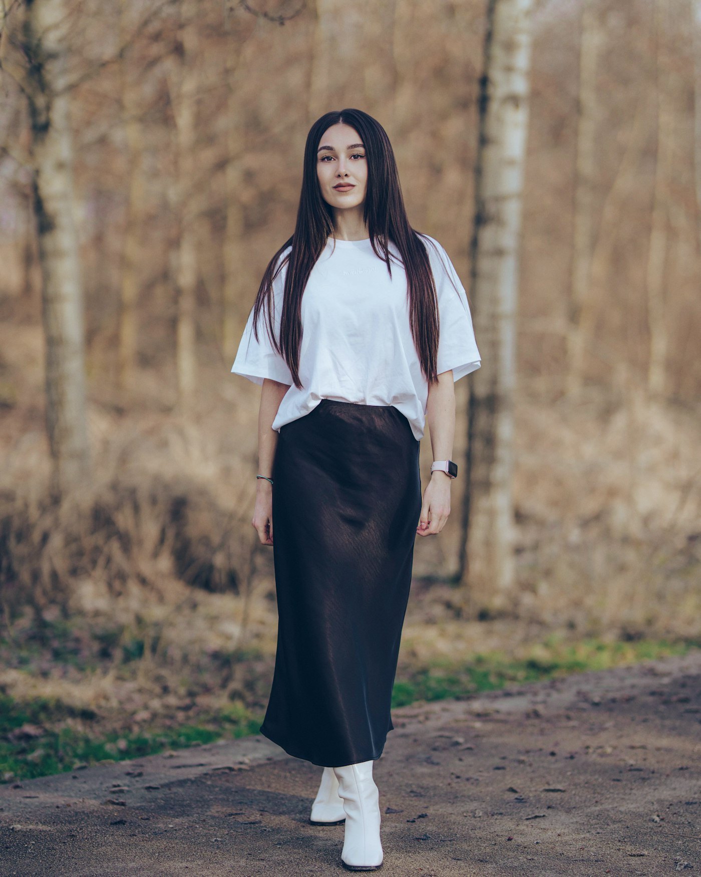 Woman with long hair wearing a white shirt and black skirt