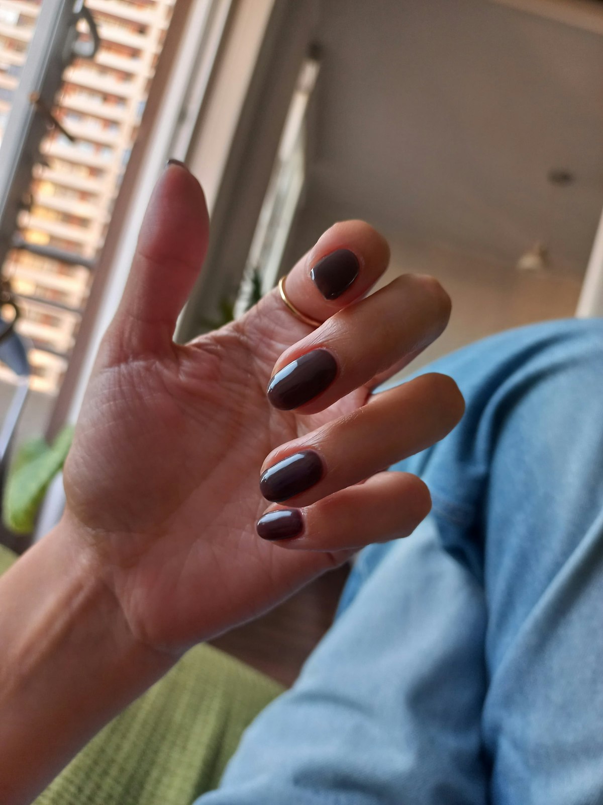 Hand with painted nails and a ring, a deep wine manicure idea