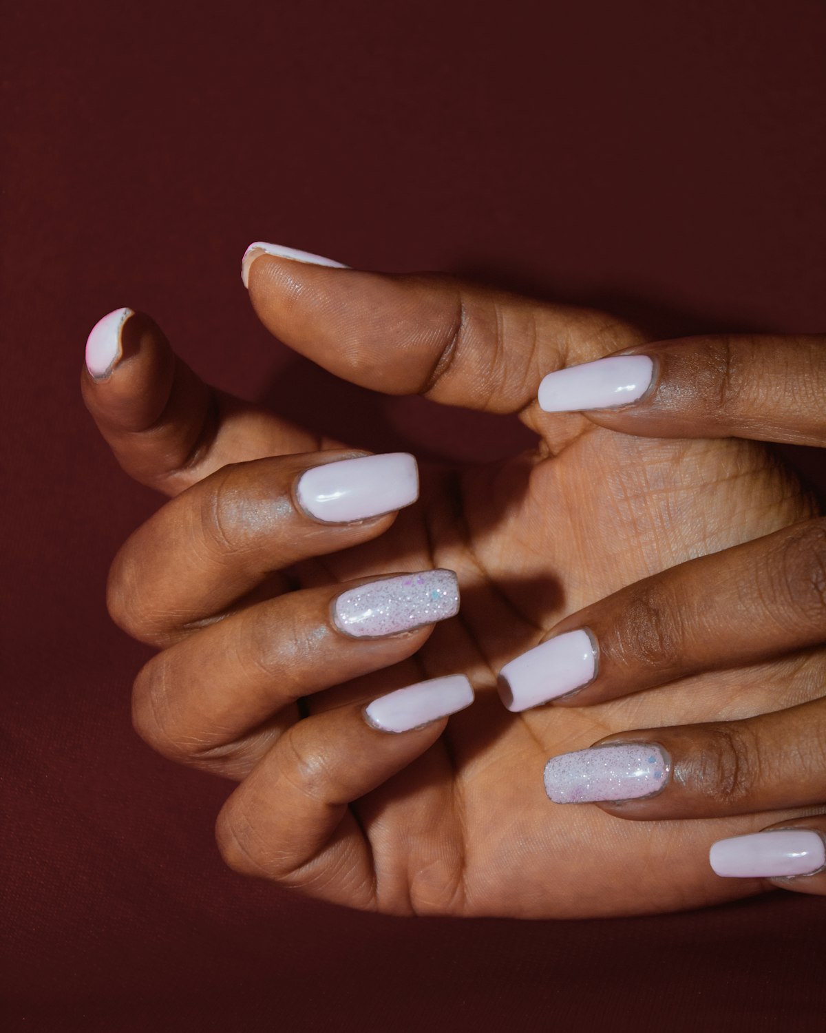 Woman hands with soft white nail polish