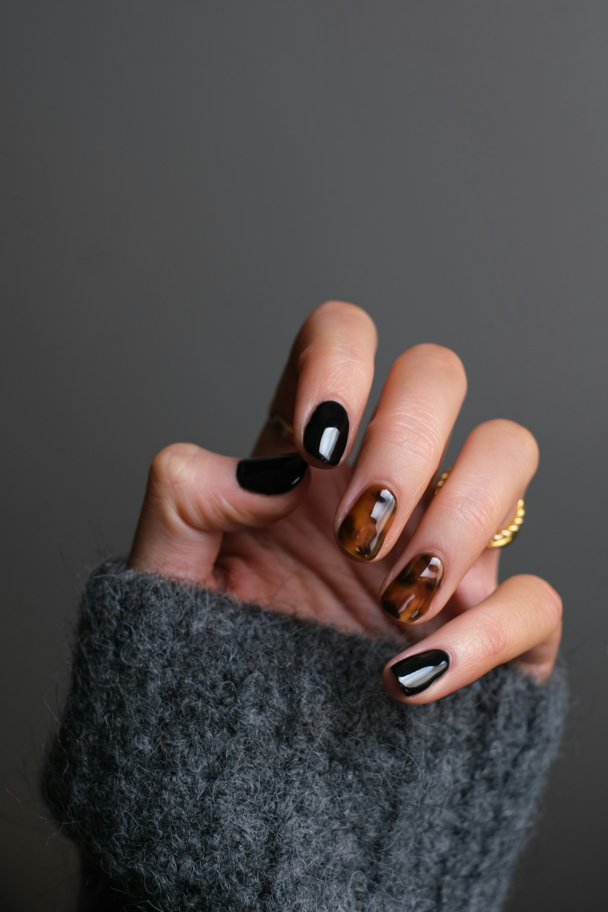 Hand with a dark and tortoiseshell manicure