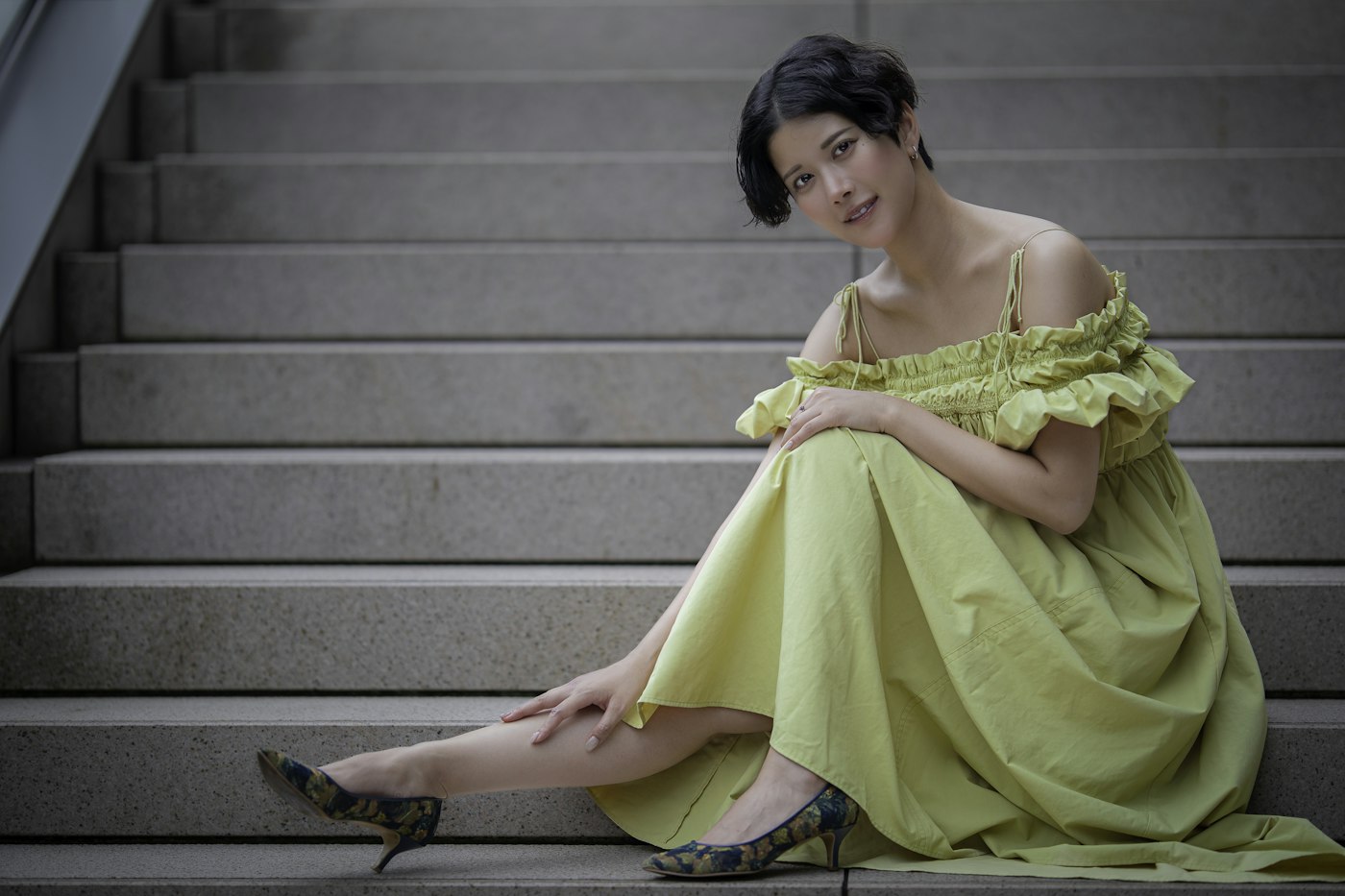 Woman in a yellow dress sitting on stone stairs