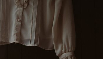 Ruffled white blouse hanging on a hook, a styling cue for the ruffled jacket and jeans look